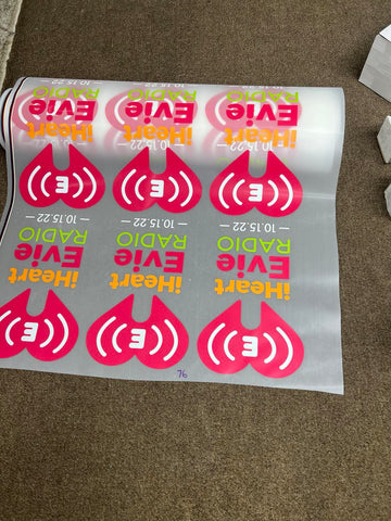 A sheet of DTF transfers with vibrant radio station logos and text, showcasing the quality and durability of DTF Gang Sheet printing.